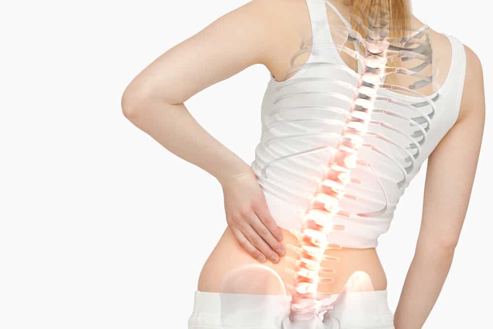 Digital composite of Highlighted spine of woman with back pain